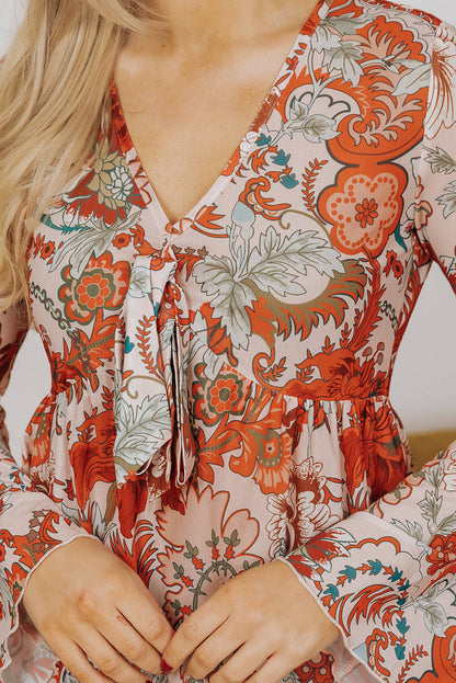 Blusa con escote en V profundo, mangas acampanadas y nudo y estampado floral naranja