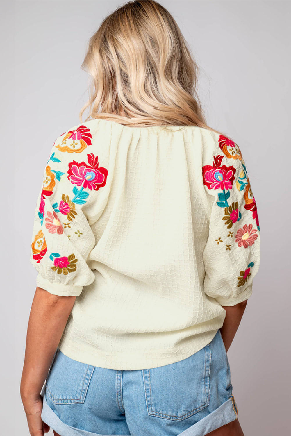 Blusa texturizada con mangas abullonadas y bordado floral en beige