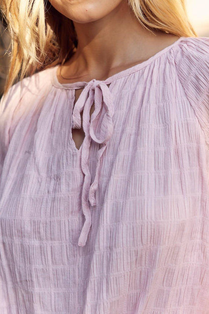 Blusa con cuello anudado y textura en febrero