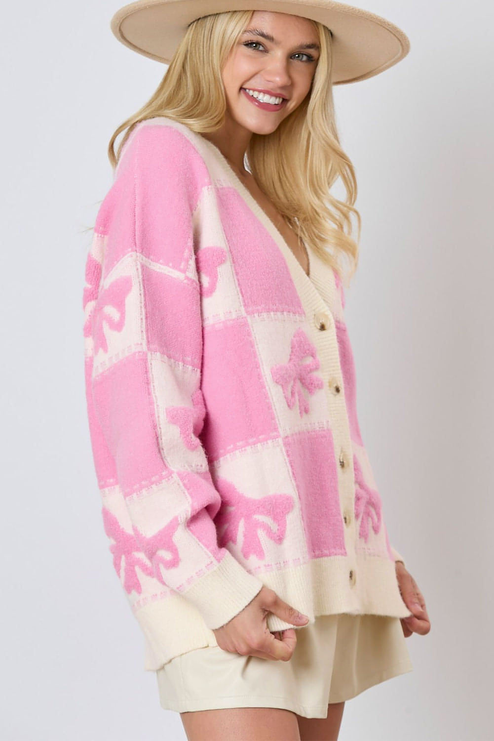 Cardigan con bottoni e scollo a V con motivo a quadretti con fiocco rosa e spalla abbassata