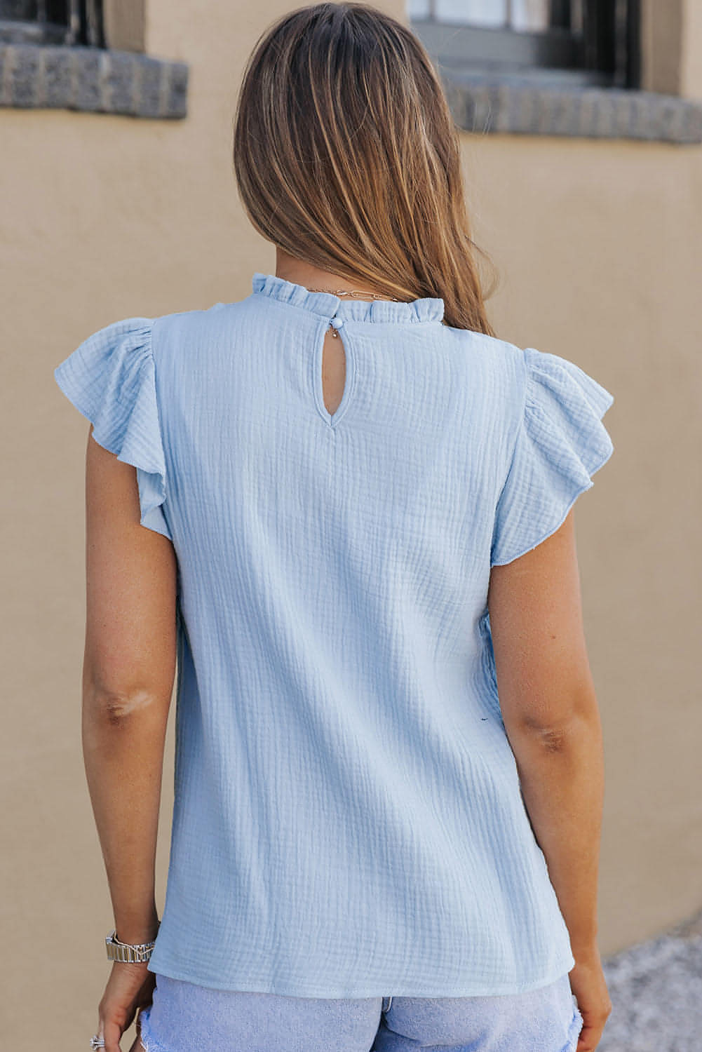 Blusa texturizada con cuello con volantes y mangas abullonadas en color azul cielo