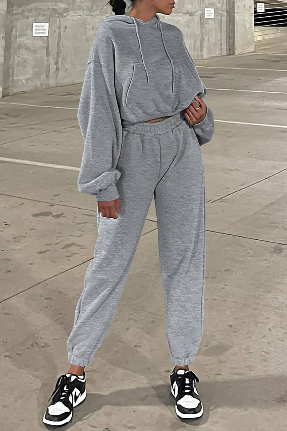 Conjunto de ropa deportiva con sudadera y pantalones deportivos con hombros caídos en color gris liso