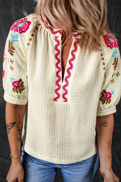 Blusa texturizada con mangas abullonadas y bordado floral en beige